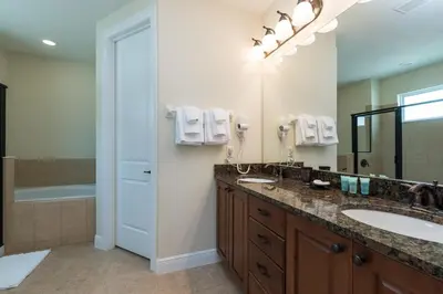 a bathroom with a double sink and a shower at Luxury Dreams Disney Home with Private Pool and Spa in Orlando