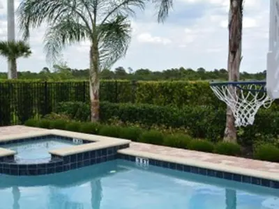 a swimming pool with a basketball hoop in a yard at Luxury Dreams Disney Home with Private Pool and Spa in Orlando