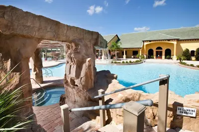 a pool at a resort with a rock wall at DISNEY area Luxurious House-Private Pool in Kissimmee