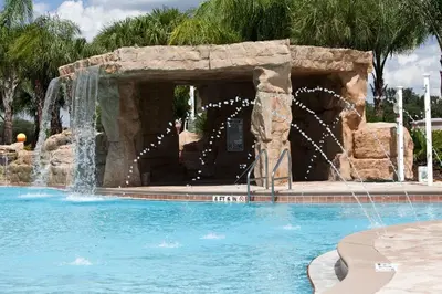 a swimming pool with a water fountain in a resort at DISNEY area Luxurious House-Private Pool in Kissimmee
