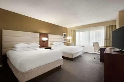 a hotel room with two beds and a desk at DoubleTree by Hilton Orlando Downtown in Orlando