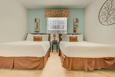 two beds in a room with a window at Gorgeous 1st-Floor, End Unit Condo w LAKEVIEW in Orlando