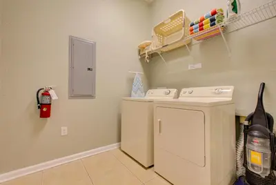 a laundry room with a white refrigerator and a fire extinguisher at Lakeview Executive Penthouse in Orlando