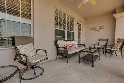 a screened in porch with chairs and a table at Lakeview Executive Penthouse in Orlando