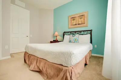 a bedroom with a large bed with blue walls at Top-Floor Luxurious LAKEVIEW Condo in Orlando
