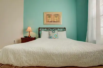 a bedroom with a bed with a blue wall at Top-Floor Luxurious LAKEVIEW Condo in Orlando