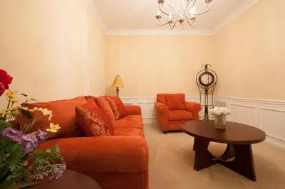 a living room with an orange couch and a table at Lovely Third-Floor Vista Cay Resort Condo in Orlando