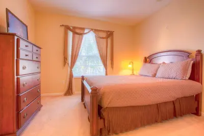 a bedroom with a bed and a dresser and a window at Lovely Third-Floor Vista Cay Resort Condo in Orlando