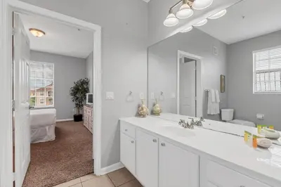 a white bathroom with a sink and a mirror at Penthouse Paradise in Orlando
