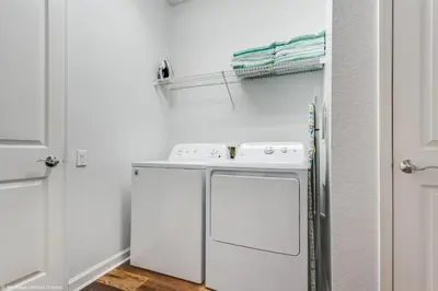 a small white laundry room with a washer and dryer at Newly Renovated 1st-Floor Condo at Vista Cay in Orlando