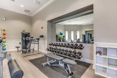 a fitness room with a large mirror and a gym at Florida Palms in Orlando
