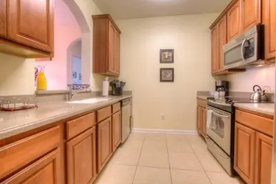 a large kitchen with wooden cabinets and a sink at Lofty Lodge in Orlando