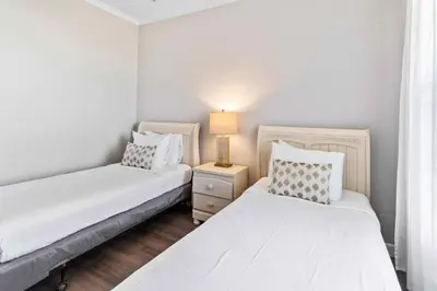 two beds in a bedroom with a lamp on a night stand at Modern Vista Cay Condo, near Universal Studios in Orlando