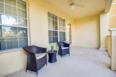 a porch with two chairs and a table and windows at Lovely Condo w FREE Access to Resort Amenities in Orlando