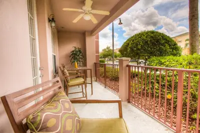 a balcony with a bench and a table at Stylish Condo at Vista Cay Resort Minutes to WDW in Orlando