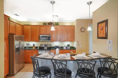 a kitchen with a table with chairs and a refrigerator at Beautiful Condo at Vista Cay Resort Near WDW in Orlando