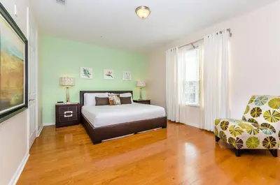 a bedroom with a bed and a chair at Treasure Palace in Orlando