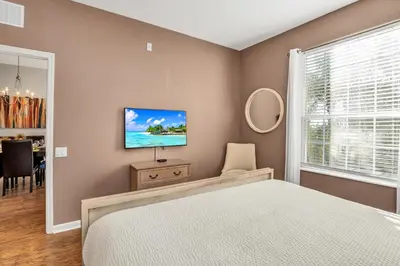 a bedroom with a bed and a tv on a wall at Newly Updated Condo w Scenic Resort View in Orlando