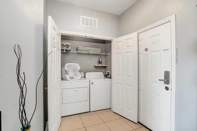 a white laundry room with a washer and dryer at Newly Updated Condo w Scenic Resort View in Orlando