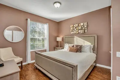 a bedroom with a large bed and a mirror at Newly Updated Condo w Scenic Resort View in Orlando