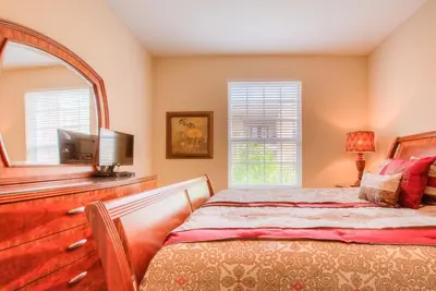 a bedroom with a bed and a mirror at Lovely Vista Cay Resort Condo, Near ClubhousePool in Orlando