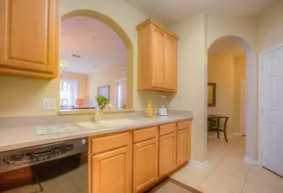 a kitchen with wooden cabinets and a counter top at Lovely Vista Cay Resort Condo, Near ClubhousePool in Orlando