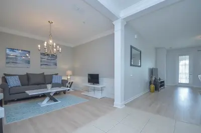 a living room with a couch and a tv at Beautiful LAKEVIEW Deluxe Condo Near Theme Parks in Orlando