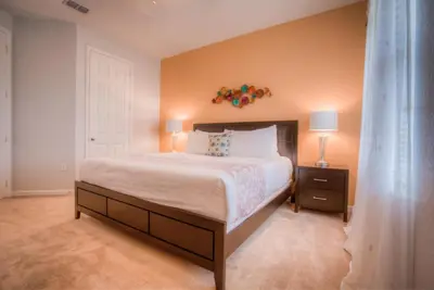 a bedroom with a large bed and two lamps at Beautiful LAKEVIEW Deluxe Condo Near Theme Parks in Orlando