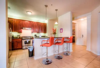 a kitchen with orange bar stools at a counter at Newly Renovated LAKEVIEW Vista Cay Condo in Orlando