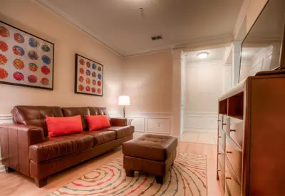 a living room with a brown couch and red pillows at Newly Renovated LAKEVIEW Vista Cay Condo in Orlando