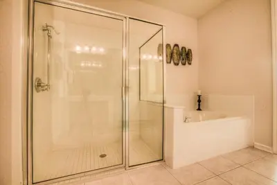 a bathroom with a glass shower with a tub and a sink at Newly Renovated LAKEVIEW Vista Cay Condo in Orlando