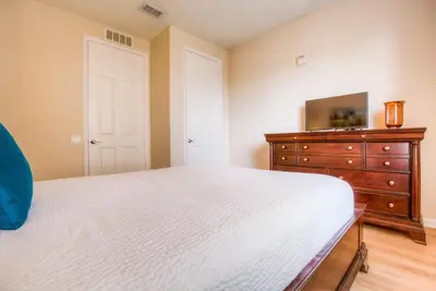 a bedroom with a white bed and a dresser at Newly Renovated LAKEVIEW Vista Cay Condo in Orlando