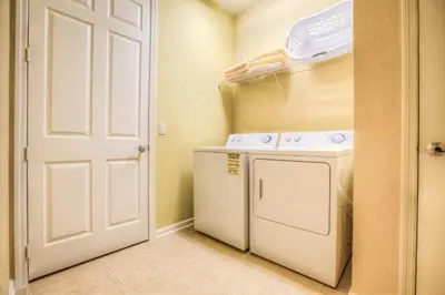 a small laundry room with a washer and dryer at Luxurious Condo wPrivate Balcony AMAZING View in Orlando