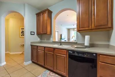 a kitchen with wooden cabinets and a black dishwasher at Gorgeous Vista Cay Condo, next to Resort Clubhouse in Orlando