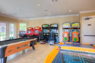 a room with a pool table and a bunch of pinball machines at Gorgeous Vista Cay Condo, next to Resort Clubhouse in Orlando