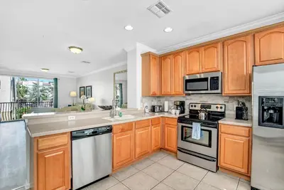 a large kitchen with wooden cabinets and appliances at NEWLY RENOVATED Townhome, Near Universal & I-Drive in Orlando