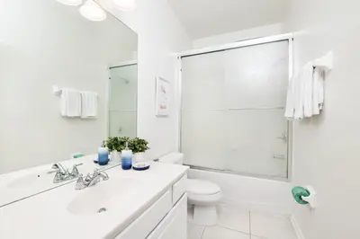 a white bathroom with a sink and a toilet at Beautiful Newly Updated Townhome Sleeps 10 in Orlando
