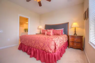 a bedroom with a large bed with pink pillows at Gorgeous Townhome w FREE Resort Access in Orlando