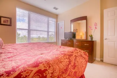a bedroom with a bed and a tv and a mirror at Gorgeous Townhome w FREE Resort Access in Orlando