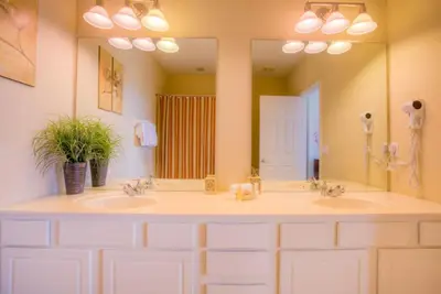 a bathroom with two sinks and a large mirror at Gorgeous Townhome w FREE Resort Access in Orlando