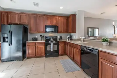 a kitchen with wooden cabinets and a stainless steel refrigerator at At Tideview in Orlando