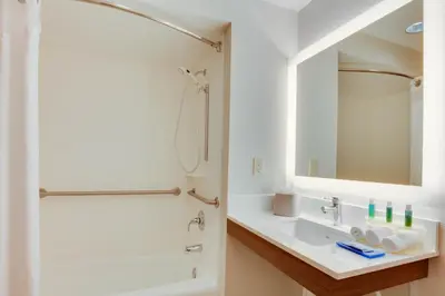 a bathroom with a sink and a shower and a mirror at Staybridge Suites Orlando South by IHG in Orlando