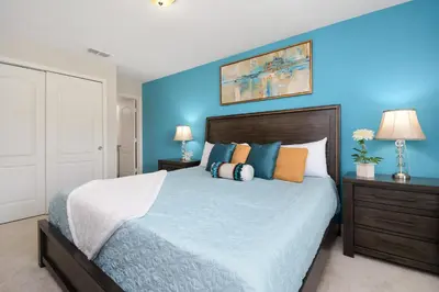 a bedroom with blue walls and a bed with pillows at Four Bedrooms TownHome 5161 in Kissimmee