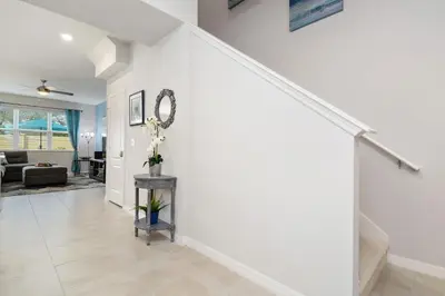 a living room with white walls and a staircase at Four Bedrooms TownHome 5161 in Kissimmee