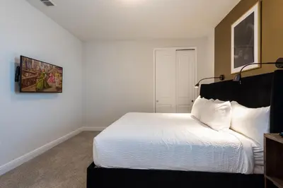 a bedroom with a white bed with a black headboard at Exquisite Home With Themed Rooms, Theater Near Disney With Waterpark & Resort Access At Encore Resort - 7736Ff in Orlando
