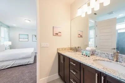 a bathroom with a double sink and a bedroom at Luxurious Home Near Disney With Game Room And Waterpark & Resort Access At Encore Resorts Reunion - 371Fl in Kissimmee
