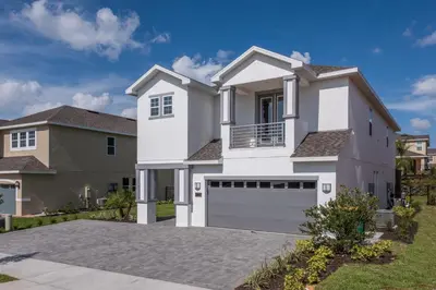 a large white house with a garage at Luxurious Home Near Disney With Game Room And Waterpark & Resort Access At Encore Resorts Reunion - 371Fl in Kissimmee