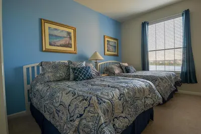 a bedroom with a bed and a couch and a window at Vista Cay Inn in Orlando