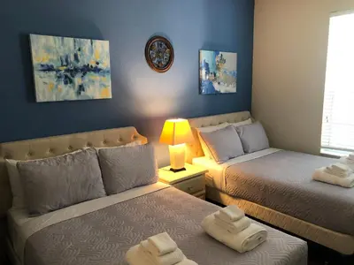 a bedroom with two beds and a couch with towels at Vista Cay Inn in Orlando