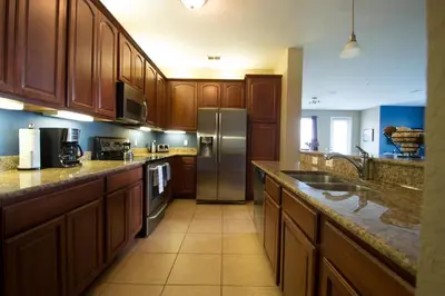 a kitchen with wooden cabinets and a stainless steel refrigerator at Vista Cay Inn in Orlando